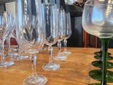 many wine glasses lined up on a wooden table