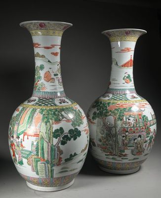 une paire de vases chinois ornés de scènes asiatiques, posés sur une table