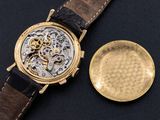 a close up of a gold watch with a brown leather strap