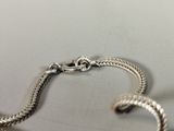a close up of a silver bracelet on a table