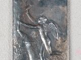 a metal plaque on the wall with a picture of a man and a dog