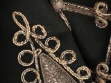 a close up of a black jacket with a gold embroidered design