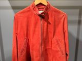 une veste rouge suspendue à un cintre dans un placard