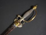 a close up of a sword on a black surface
