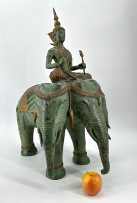 a statue of a man riding an elephant next to an orange