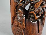 a wooden vase with carvings on it on a table