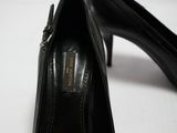 une paire de chaussures à talons hauts noires posées sur une surface blanche