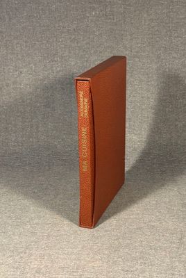 an orange book with a gold cover sitting on top of a gray surface
