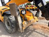 a bull that is standing next to a construction vehicle