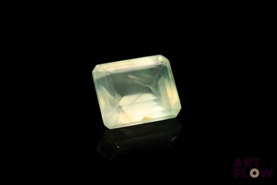 une image représentant un quartz vert posé sur une surface noire