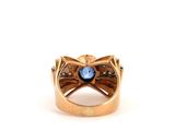 a close up of a gold ring with a blue stone