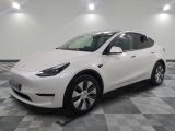La Tesla Model Y blanche est garée dans une grande pièce.