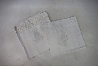 two white towels on a table with a white table cloth