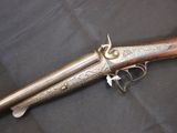 a very old gun with a wooden handle on a black background
