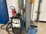 two oxygen cylinders and a welding machine in a garage