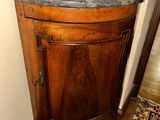 a corner cabinet with a marble top in a corner