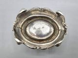 a silver bowl with a spoon in it on a table