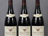 three bottles of wine are lined up on a table