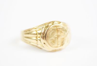 a gold signet ring with a cross on it