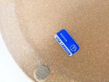 a brown vase that has a blue label on it
