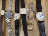 many different types of watches displayed on a wooden table
