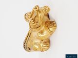 a gold figurine of an elephant on a white surface