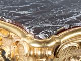 a marble topped table with gold trimmings and a black marble top