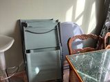 une table et des chaises en verre dans une pièce avec du parquet