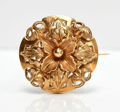 a close up of a gold ring with a flower on it