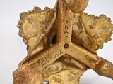 a gold figurine with a cross on top of it