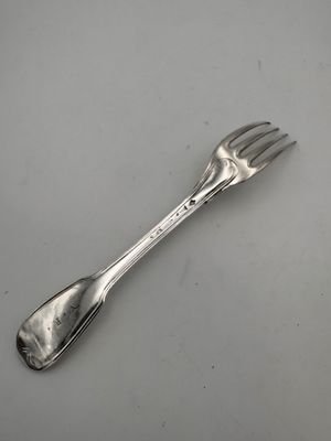 une cuillère et une fourchette posées sur une table, sur fond blanc