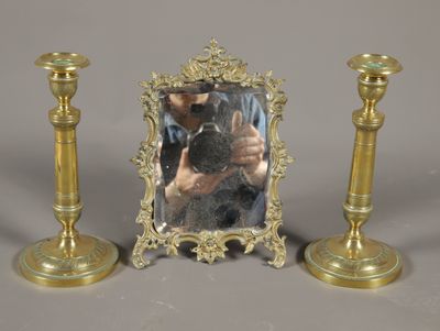 une photo représentant un miroir et deux bougeoirs posés sur une table