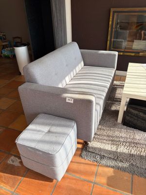 un canapé et un pouf dans un salon avec une table basse
