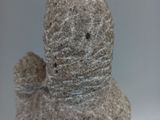 a stone sculpture of a duck on a white surface