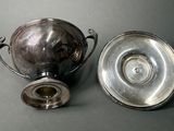 a silver cup and a silver bowl on a table