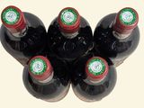 six bottles of wine are lined up in a row on a white surface