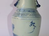 a blue and white vase sitting on a white surface