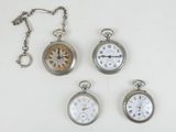 four different types of pocket watches are displayed on a white surface