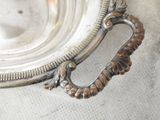 a silver plate with a handle on it on a table
