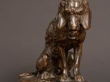 bronze statue of a dog sitting on a wooden table