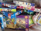 a pile of puzzles on the floor of a living room