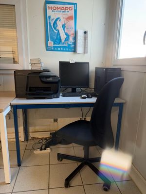 a desk with a computer and a printer on it