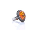 a close up of a ring with an orange stone in it
