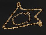 un gros plan d'un collier et d'un bracelet en or posés sur une surface noire