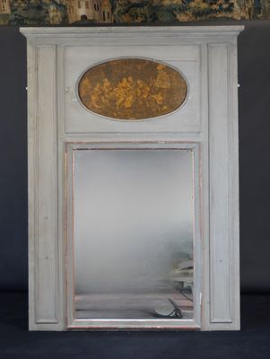 un miroir dans un coin d'une pièce où est accroché un tableau au mur