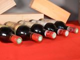several bottles of wine are lined up on a red table cloth