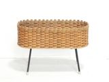 an image of a wicker basket sitting on a metal stand
