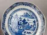 pair of blue and white plates with a landscape scene on them
