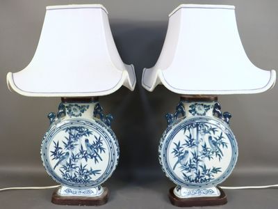 pair of blue and white vases with lamps on wooden bases