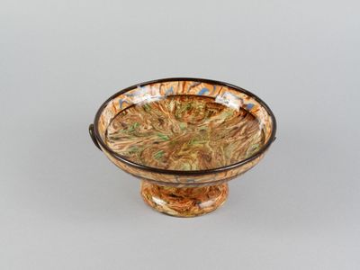 a glass bowl with a flower in it on a table